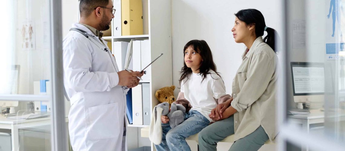 A doctor diagnosing a child who came with her mother